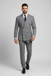 Man wearing gray pinstripe double-breasted suit with tailored fit and navy tie.